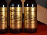 three bottles of wine sitting on top of a table next to a wooden box