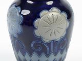 a blue vase with a flower design on it