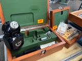 une boîte verte posée sur une table, avec un téléphone à l'intérieur