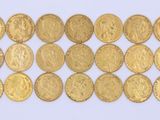 a close up of a bunch of gold coins on a white surface