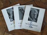 three books on a wooden floor with a picture of an old woman