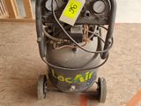 a small air compressor sitting on the floor in the garage