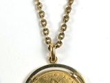 un gros plan d'un collier composé d'une pièce de monnaie suspendue à une chaîne