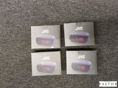 quatre boîtes de réveils JVC posées sur un sol recouvert de moquette