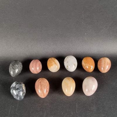 a group of seven different colored stones sitting on top of a black surface