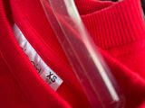 a close up of a red shirt with a cell phone in it