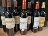 plusieurs bouteilles de vin rouge sont alignées sur une table
