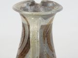 a brown and white vase sitting on a white surface