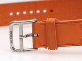 an orange leather watch strap with a silver buckle on a white surface