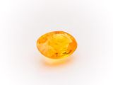 a yellow sapphire stone on a white background