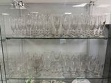 beaucoup de verres posés sur une étagère en verre dans une pièce