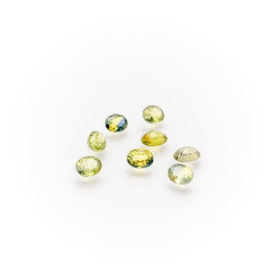 a group of yellow and green tourmaline gems on a white background