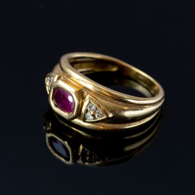 Une bague jonc en or 750‰ jaune serti d'un rubis épaulé de d…