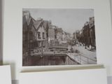a black and white photo of a canal in a city