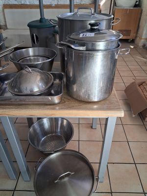 several pots and pans are on a table in a kitchen