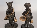 two figurines of a boy and a girl with bells