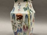 a vase with a handle that has a painting on it