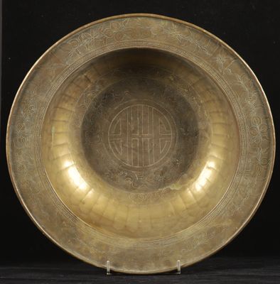an antique brass bowl with a circular design on the rim