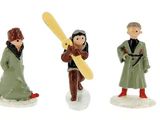 four figurines of people and a dog on a white surface