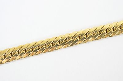 a close up of a gold chain on a white surface