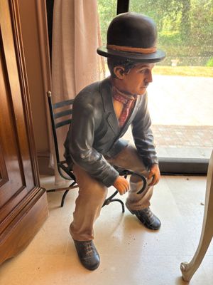 une statue représentant un homme assis sur une chaise