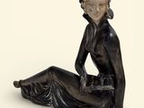 une statue représentant une femme assise par terre