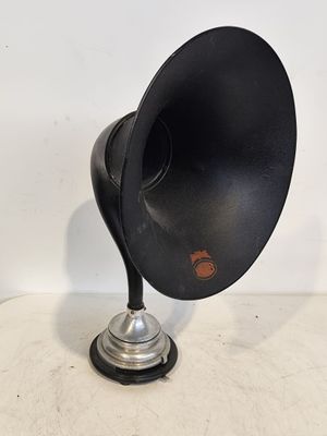 un vieux gramophone noir et argenté posé sur un socle en métal