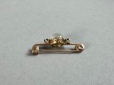 a close up of a gold pin with a skull on it