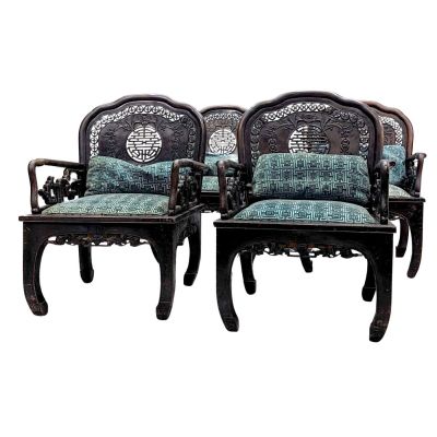 pair of carved wood chairs with blue and green upholstered cushions
