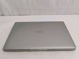 a laptop on a bed with a white sheet in the background