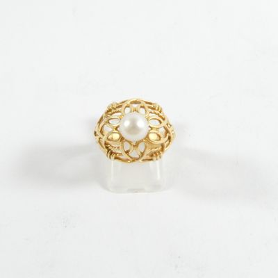 gros plan d'une bague en or avec une perle au centre