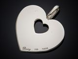 a close up of a heart shaped pendant on a black surface