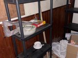 a black shelf with plates and bowls on it in the corner of a room