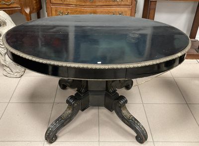 une table noire avec un plateau en verre, posée sur un sol carrelé