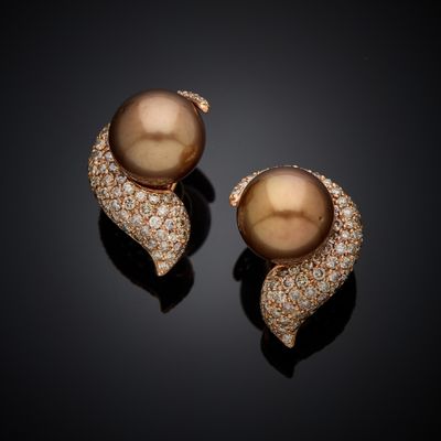 a pair of brown pearls and diamonds on a black surface