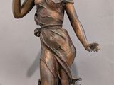 a bronze statue of a woman with a basket of flowers