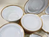 a lot of white and gold plates on the table