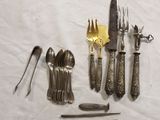 many different types of silverware on a white table