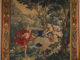 une tapisserie accrochée au mur d'une pièce où se trouve un tableau