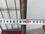 someone is measuring the length of a metal pole with a tape