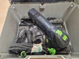 a black and green electric tool in a plastic container