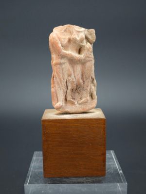 une statue antique représentant un homme tenant une femme dans ses bras, posée sur un socle