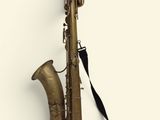 un gros plan d'un saxophone sur fond blanc, muni d'une sangle noire