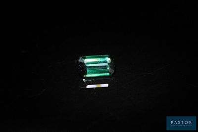 a close up of a piece of emerald on a black surface
