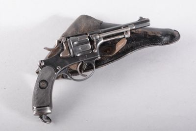 gros plan d'un revolver sur une surface blanche