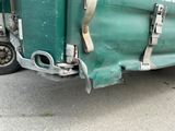 une photo d'un semi-remorque vert garé sur le bord de la route