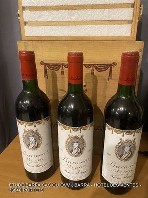 three bottles of red wine sit on a table next to a wooden box