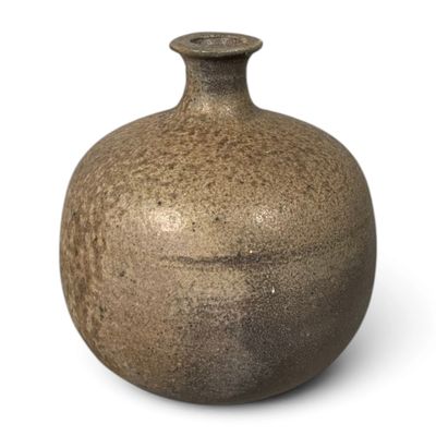 un vase brun posé sur une surface blanche