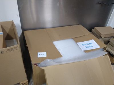de nombreux cartons posés par terre à côté d'un réfrigérateur