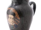 a black vase with a picture of a man on it